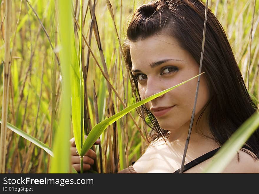 Young woman smiling in a field of grass. Young woman smiling in a field of grass