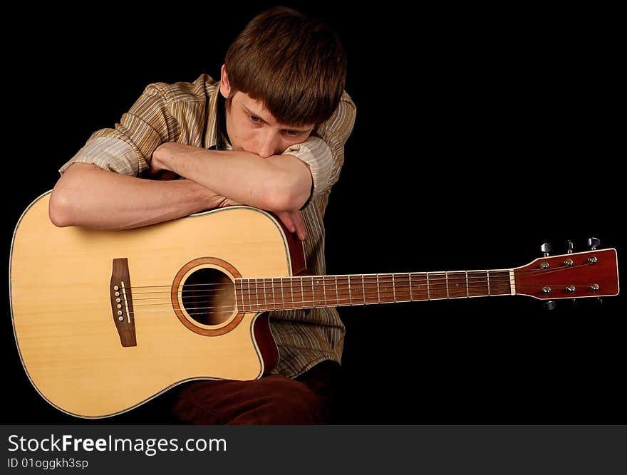 Young musician playing classic guitar isolated on black. Young musician playing classic guitar isolated on black