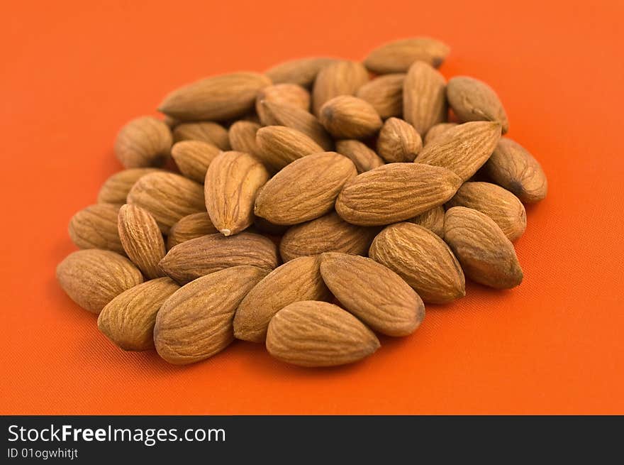 Almonds, orange background.