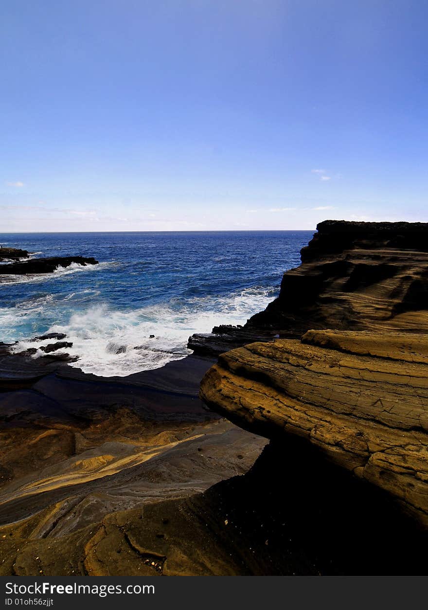 This is a picture of a canyon of volcanic rock against a blue sky in hawaii.