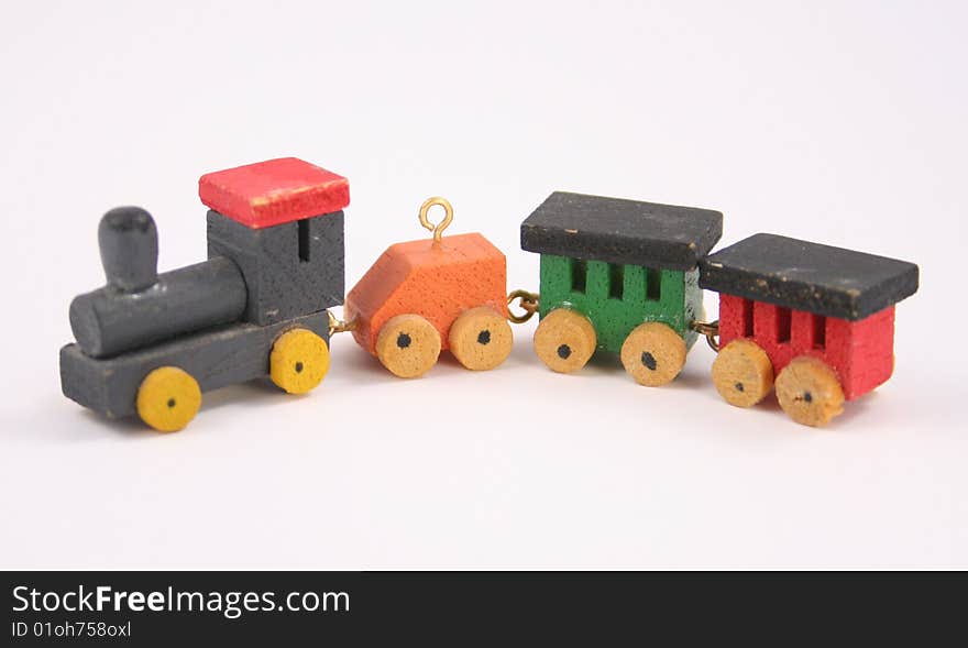 Old wooden miniature toy train with locomotive and caboose with a white background.