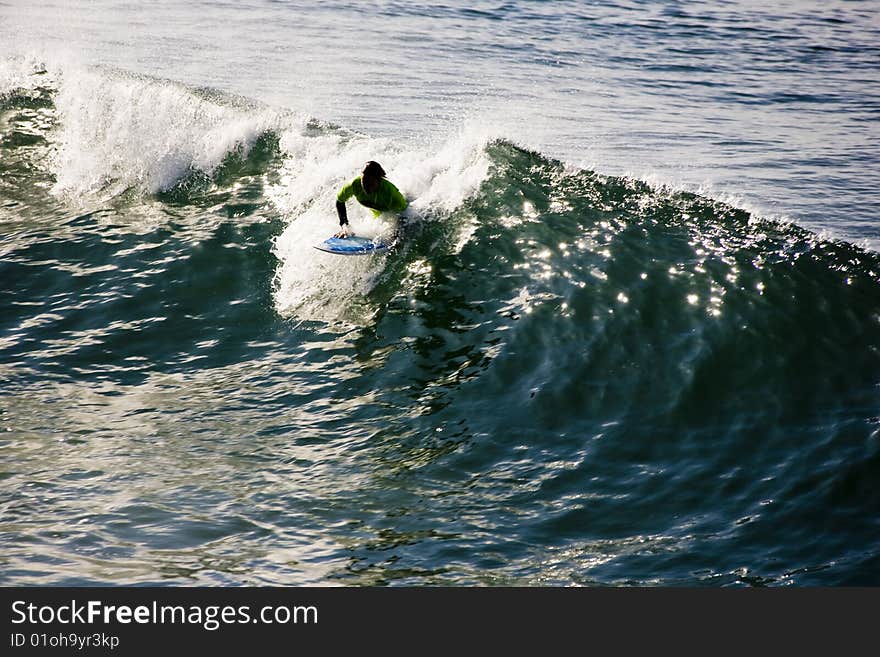 Surfer catching a nice wave during a high school surf contest. Surfer catching a nice wave during a high school surf contest