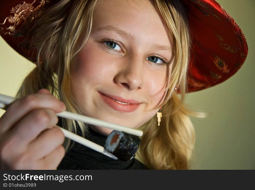 A smiling girl with chopsticks and sushi. A smiling girl with chopsticks and sushi