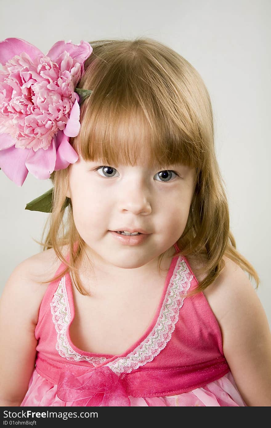 Small girl with the pink flower in her hair. Small girl with the pink flower in her hair