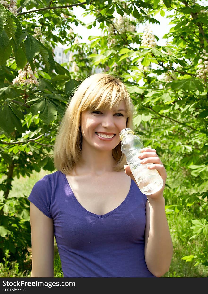 Young woman drinking water at outdoors workout