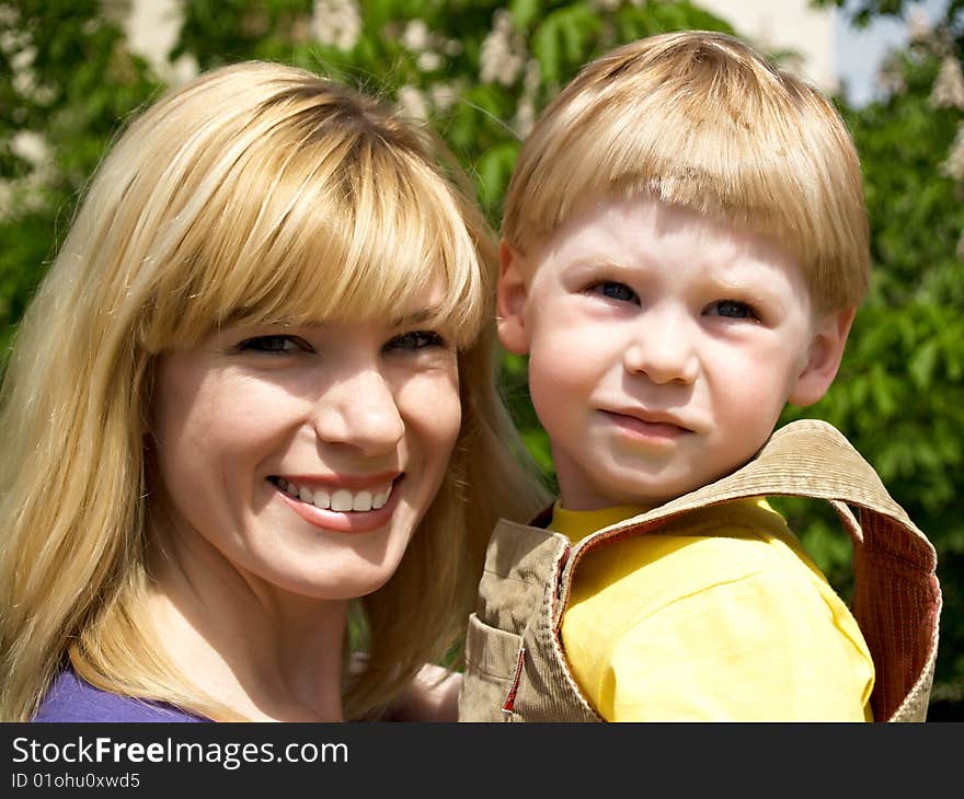 Woman and young boy outdoors embracing and smiling. Woman and young boy outdoors embracing and smiling