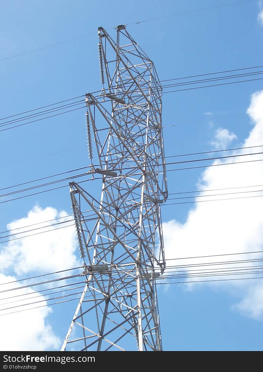 A photo of a high tension tower with a nice white cloud background. A photo of a high tension tower with a nice white cloud background.