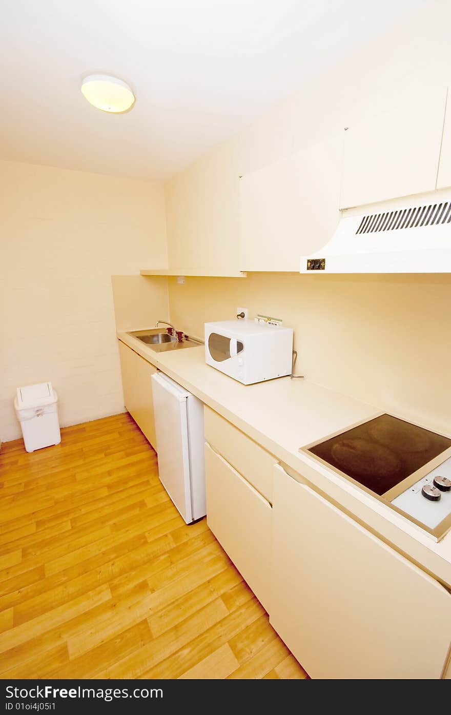 The neatly laid out pantry of a hotel room, comprising of a microwave oven, an electric stove, a sink and a mini refrigerator. The neatly laid out pantry of a hotel room, comprising of a microwave oven, an electric stove, a sink and a mini refrigerator.