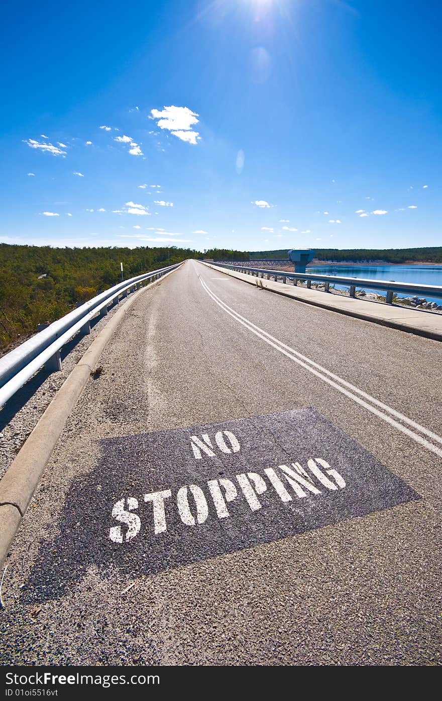 A no stopping sign on a two lane highway.