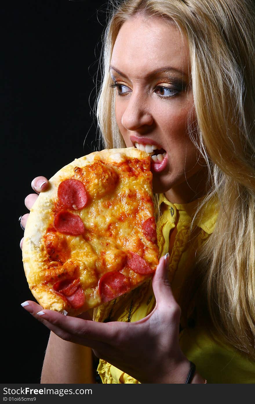 A beautiful young woman eating pizza