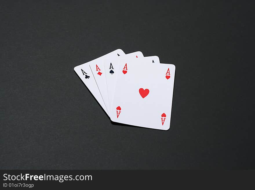 Four aces cards on black background.