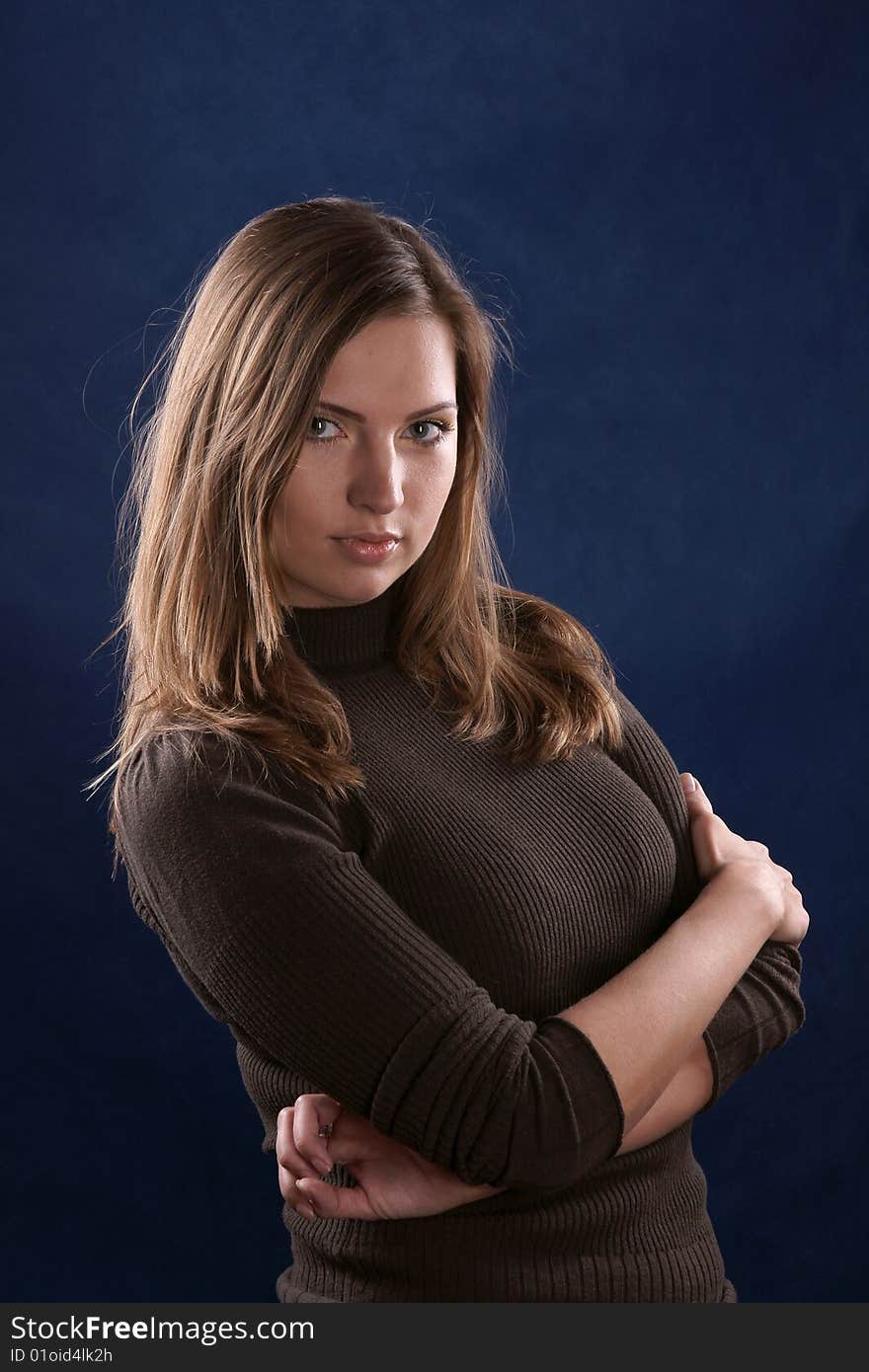 The portrait of the beautiful girl is photographed on a dark blue background