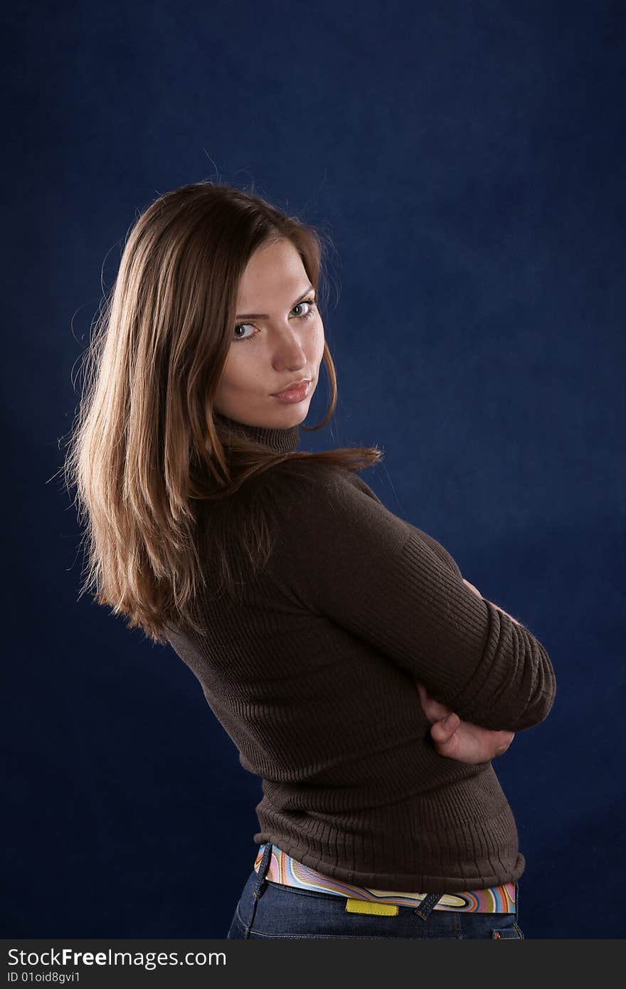 The portrait of the beautiful girl is photographed on a dark blue background