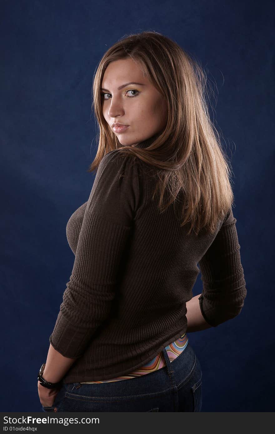 The portrait of the beautiful girl is photographed on a dark blue background