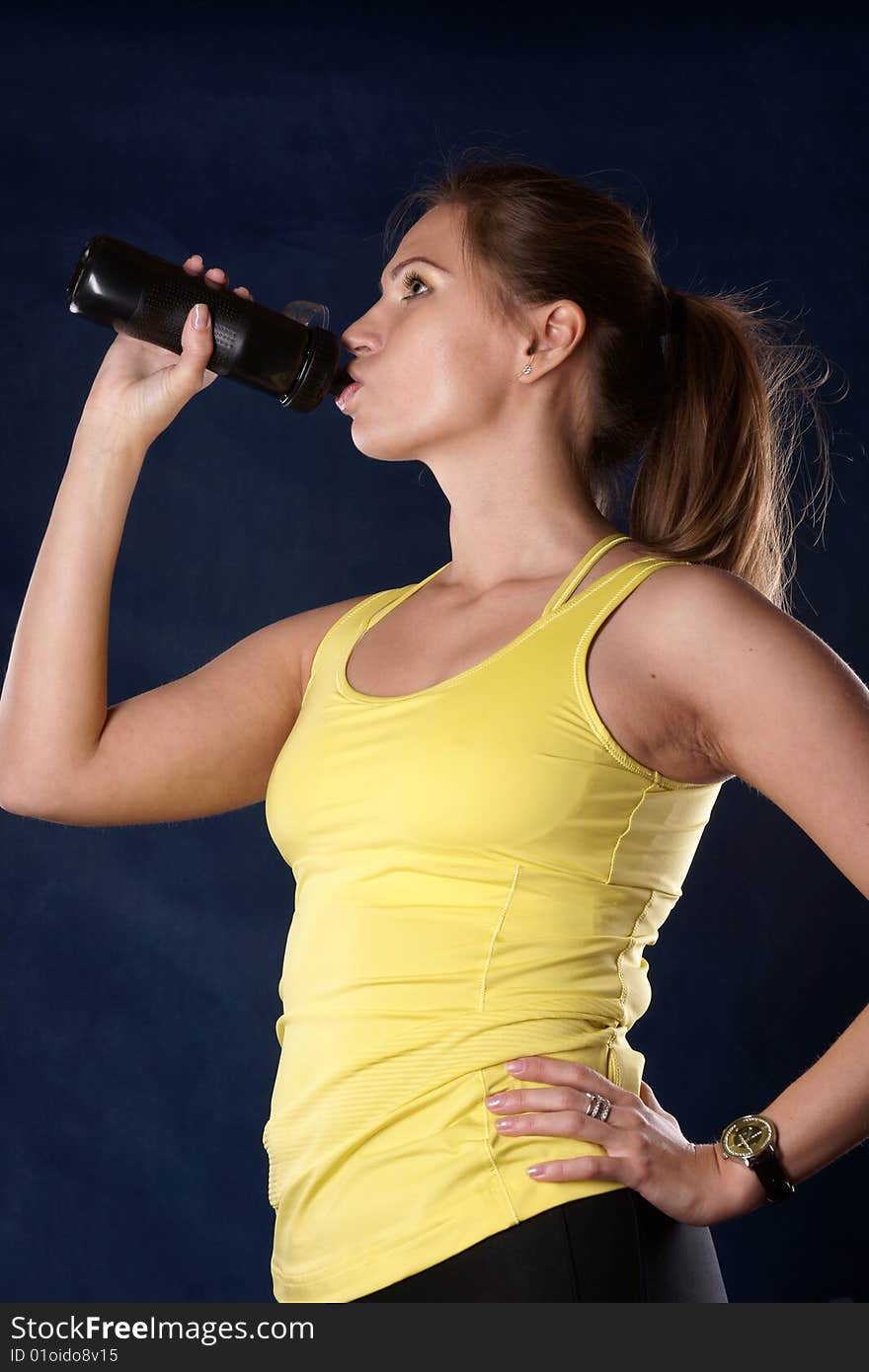 The sports girl is photographed on a dark blue background