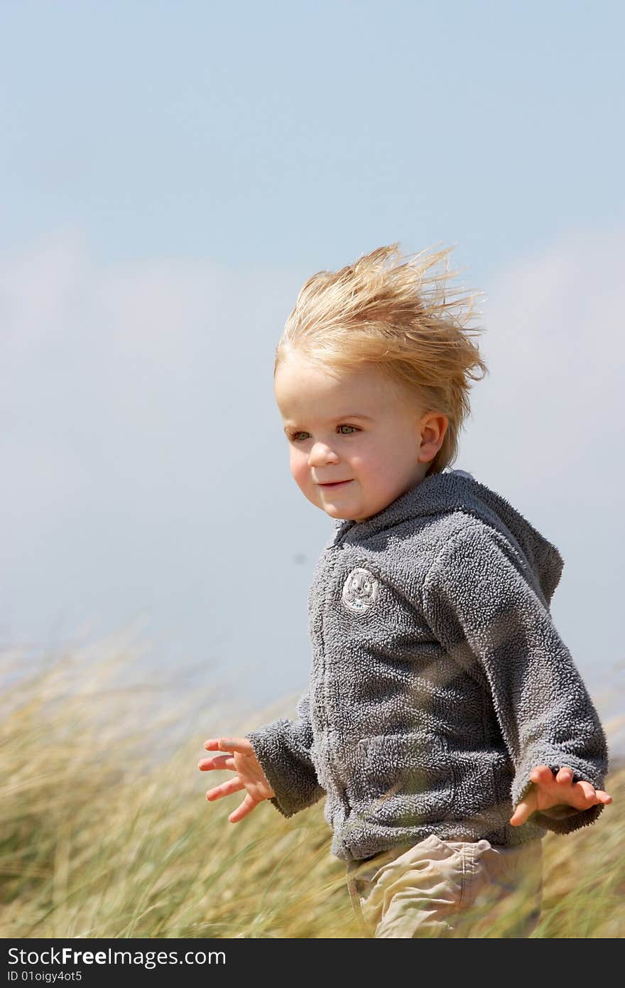 Little boy playing in sand dunes in uk. Little boy playing in sand dunes in uk