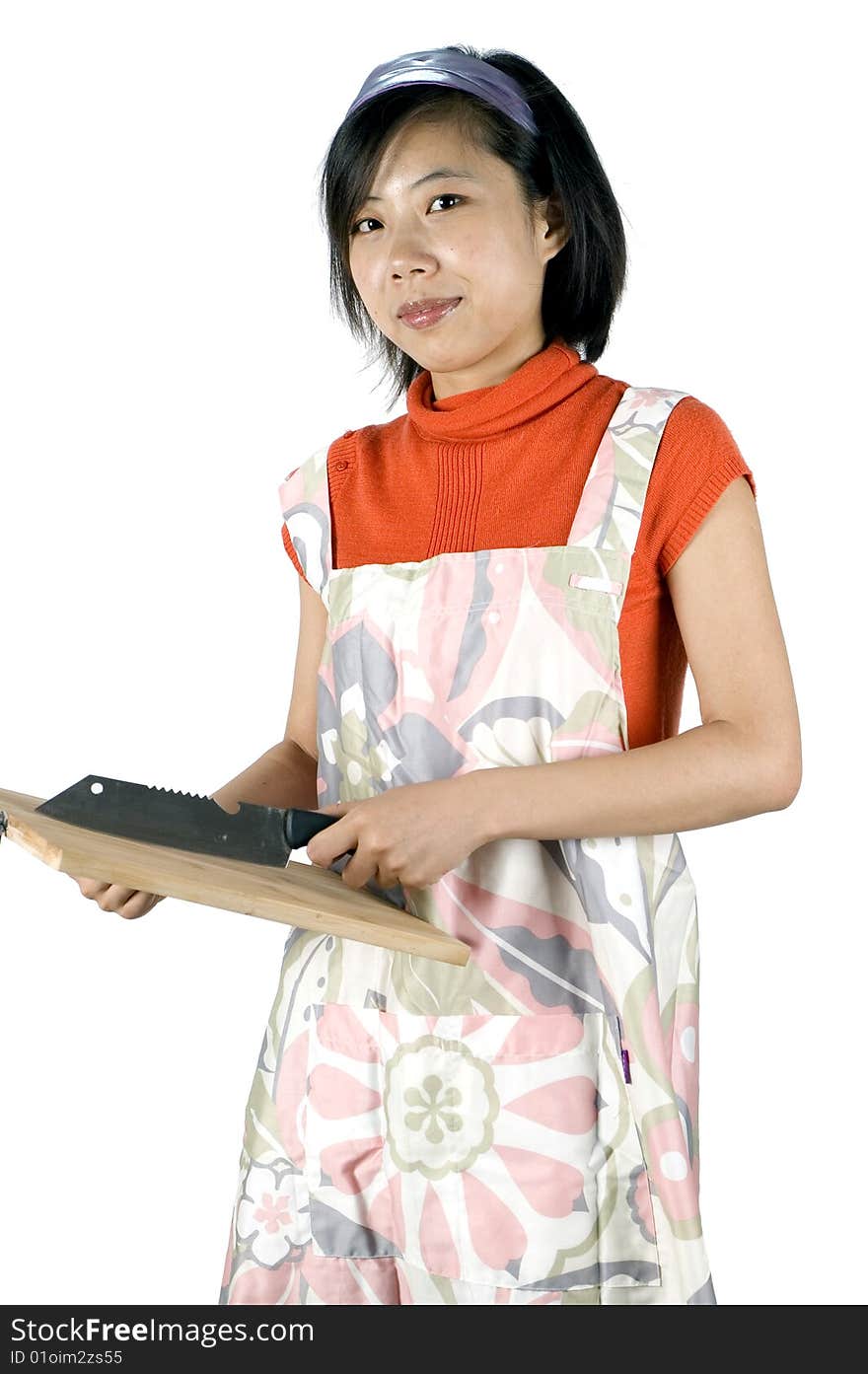 Young Asian girl, preparing food, holding wooden tray and knife. Model wearing cooking apron. Young Asian girl, preparing food, holding wooden tray and knife. Model wearing cooking apron.