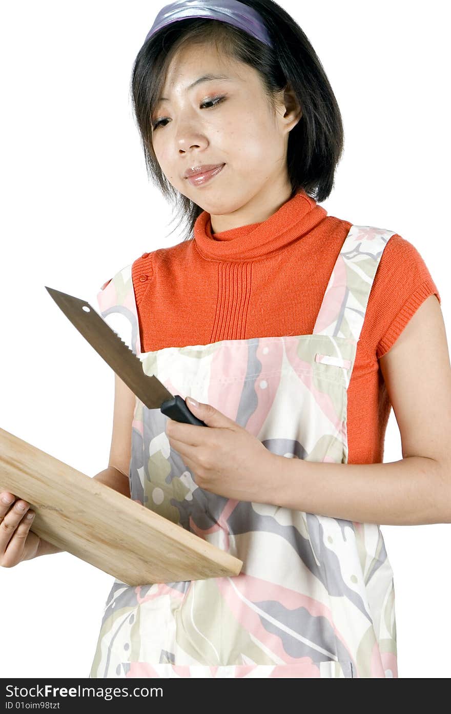 Young Asian girl, preparing food, holding wooden tray and knife. Model wearing cooking apron. Young Asian girl, preparing food, holding wooden tray and knife. Model wearing cooking apron.