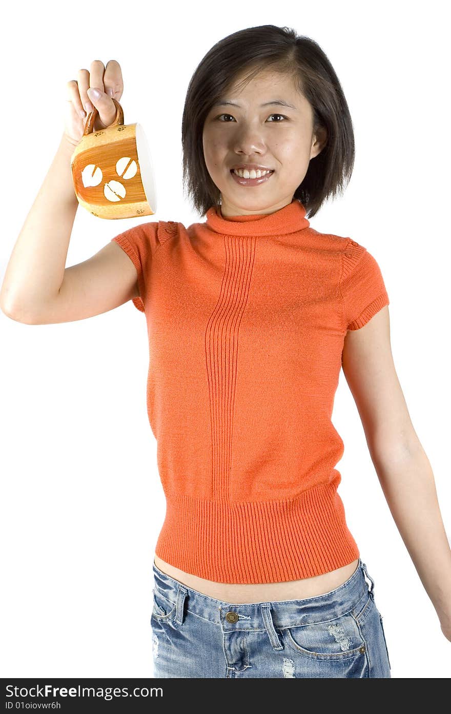 Charming Asian girl holding big mug with tea. Girl with kind face expression, wearing orange sweater. Charming Asian girl holding big mug with tea. Girl with kind face expression, wearing orange sweater.