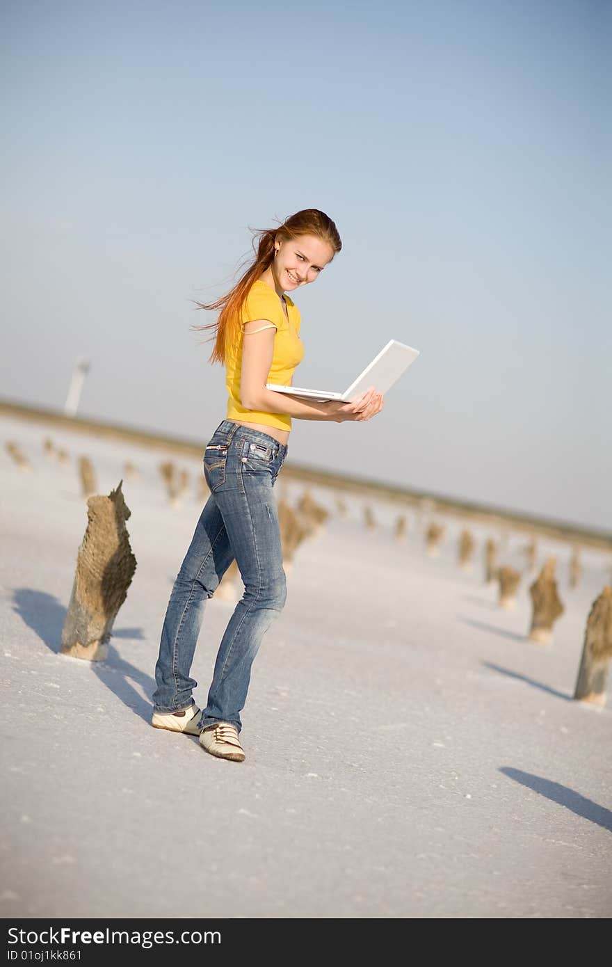 Happy girl with notebook on the sand