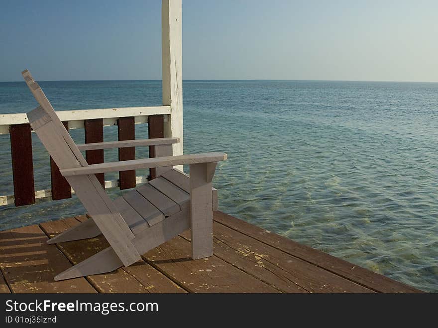 A chair on the veranda of a bungalow over looking the Caribbean Sea. A chair on the veranda of a bungalow over looking the Caribbean Sea