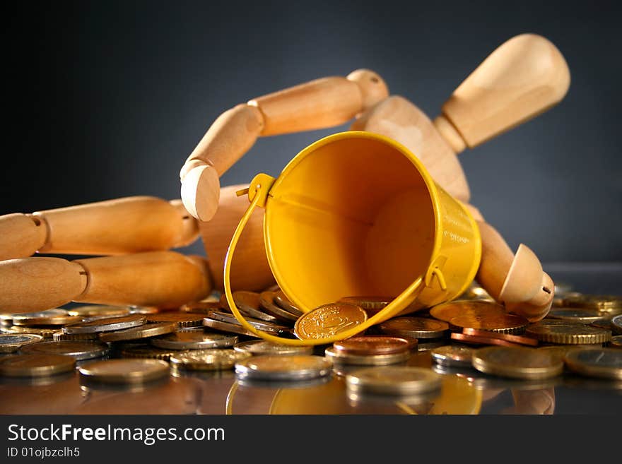 Financial conceptual image. Wooden man and coins. Financial conceptual image. Wooden man and coins.