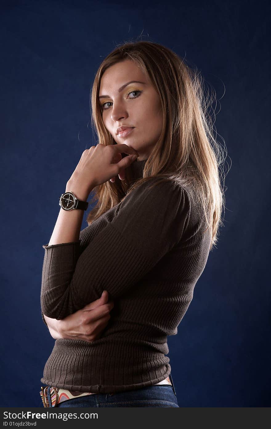 The portrait of the beautiful girl is photographed on a dark blue background