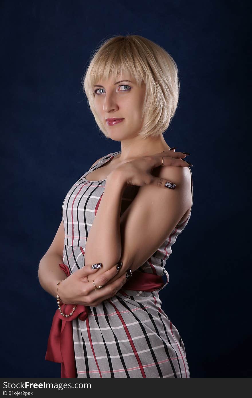 The portrait of the beautiful girl is photographed on a dark blue background