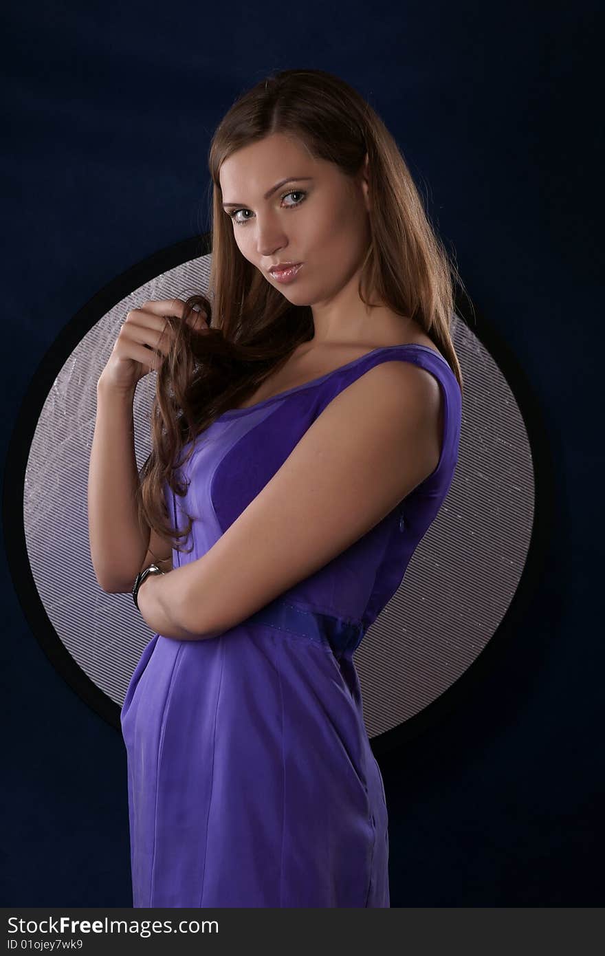 The portrait of the beautiful girl is photographed on a dark blue background