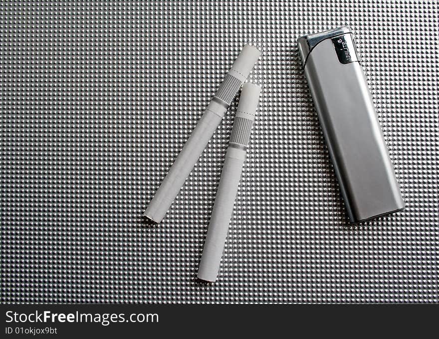 Lighter and cigarettes on a grey background