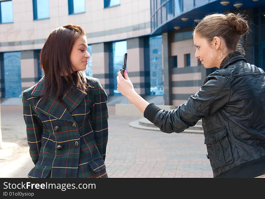 Girl take a picture of an other girl on a street. Girl take a picture of an other girl on a street