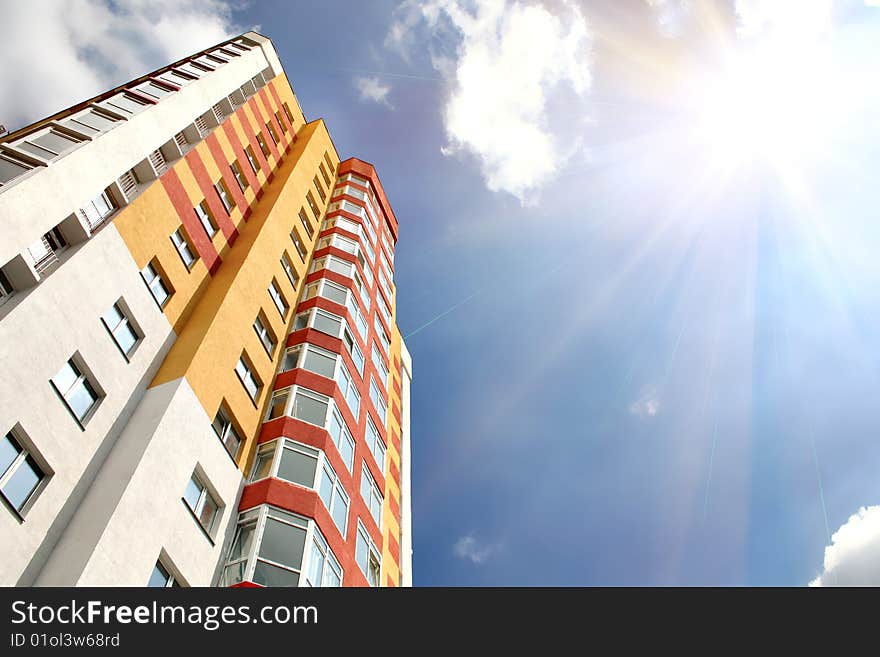 City building against of sky and bright sun