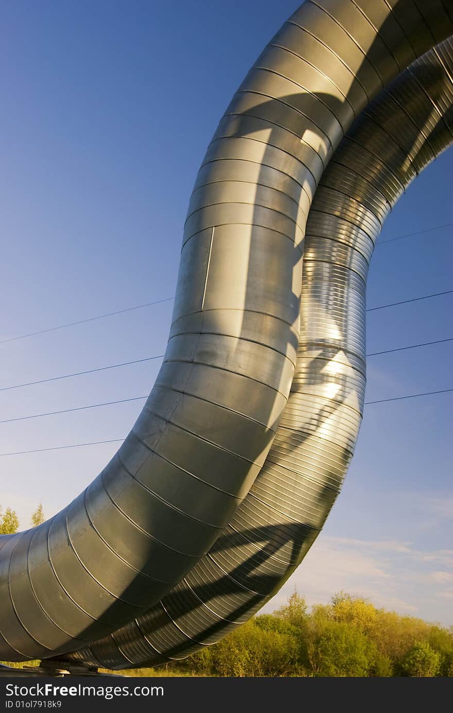 Industrial pipelines on pipe-bridge against blue sky. Industrial pipelines on pipe-bridge against blue sky.