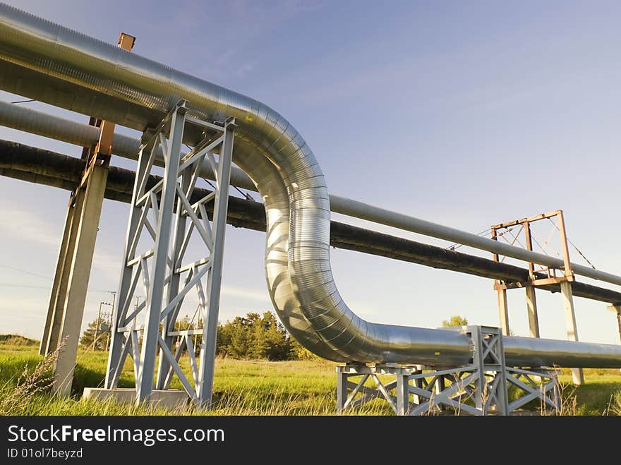 Industrial pipelines on pipe-bridge against blue sky. Industrial pipelines on pipe-bridge against blue sky.