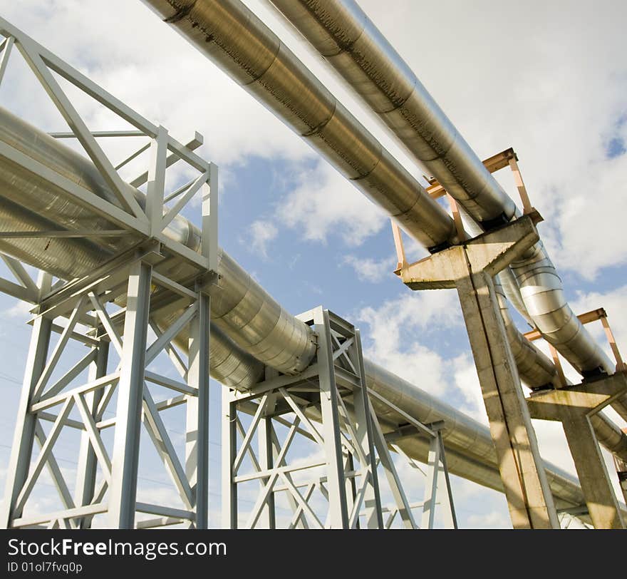 Industrial pipelines on pipe-bridge against blue sky. Industrial pipelines on pipe-bridge against blue sky.