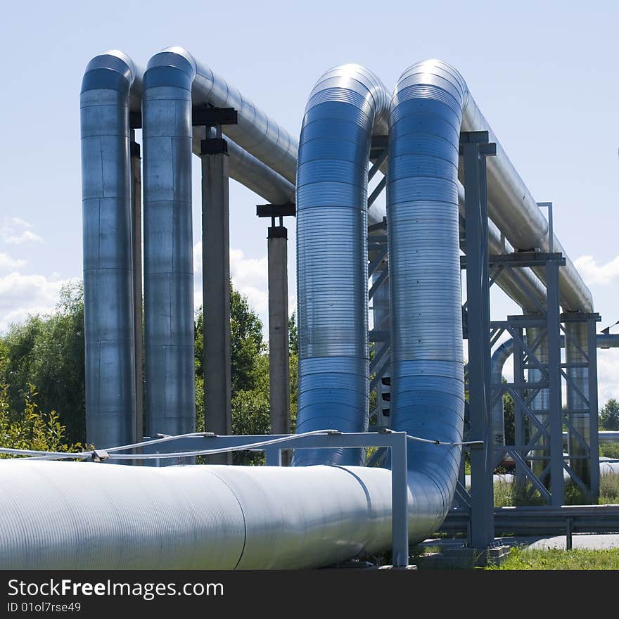 Industrial pipelines on pipe-bridge against blue sky. Industrial pipelines on pipe-bridge against blue sky.