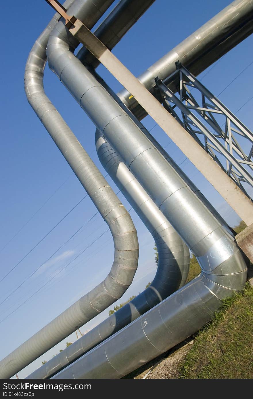 Industrial pipelines on pipe-bridge against blue sky. Industrial pipelines on pipe-bridge against blue sky.