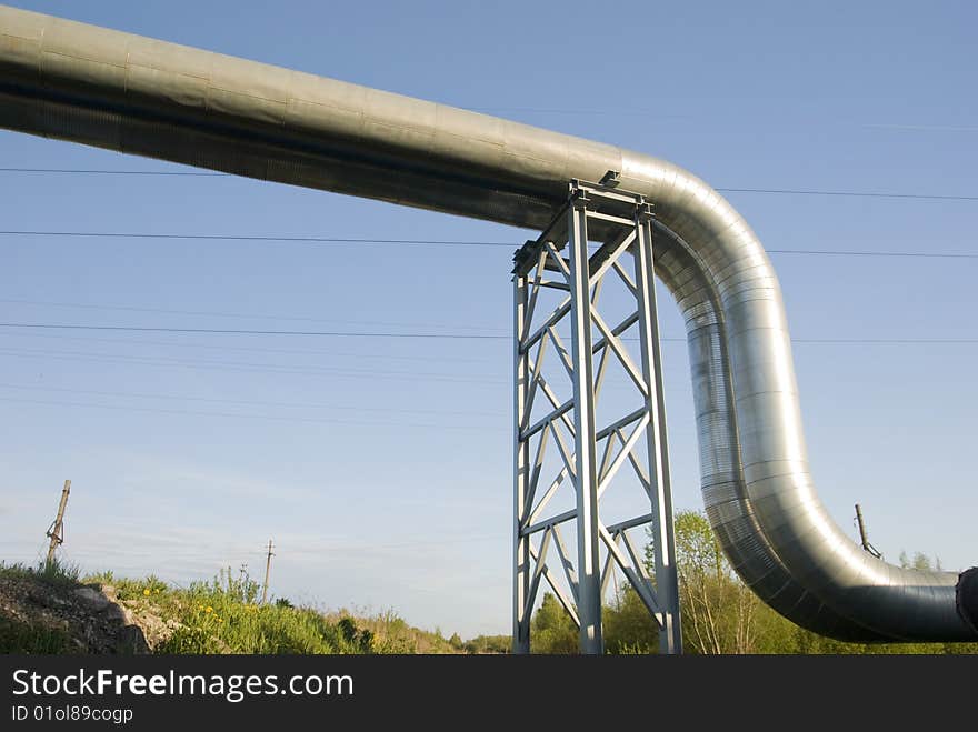 Industrial pipelines on pipe-bridge against blue sky. Industrial pipelines on pipe-bridge against blue sky.