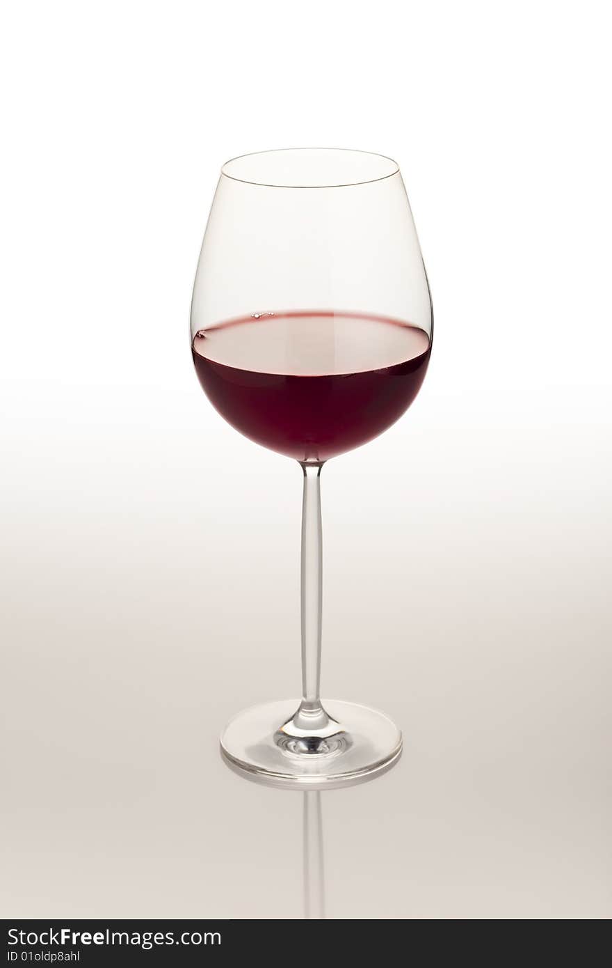 Red wine glass on reflective white table. Red wine glass on reflective white table