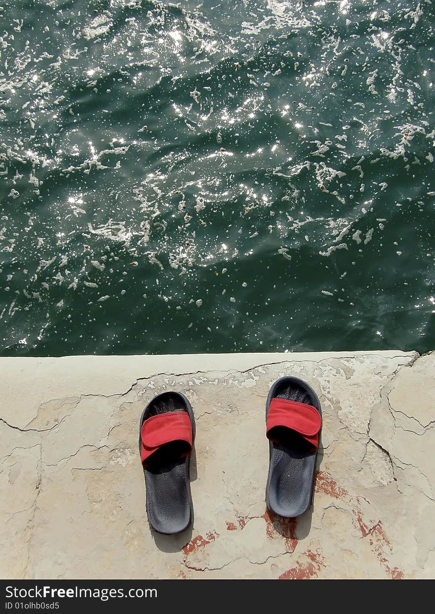 Slip-on shoes without man and dirty sea. Slip-on shoes without man and dirty sea