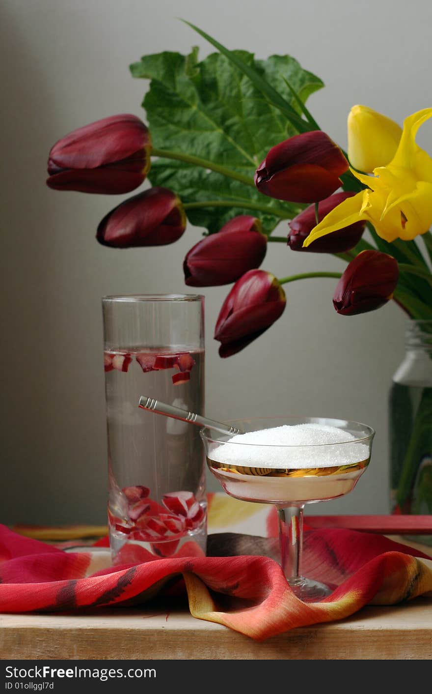 Tulips and rhubarbs drink on the table with sugar