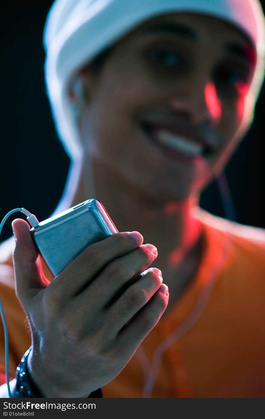 A handsome asian male listening to music with mixed lighting