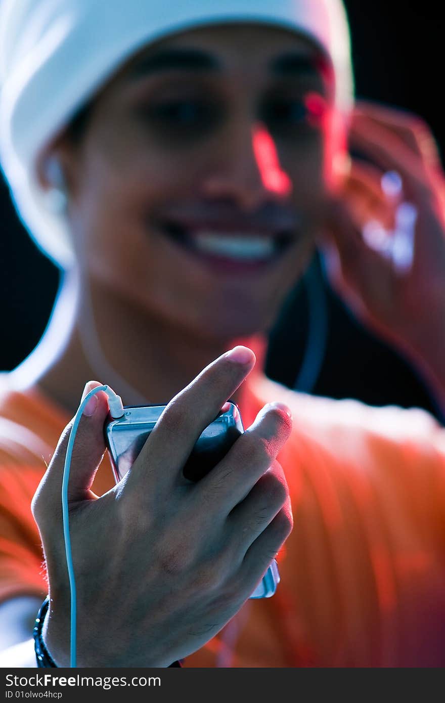 A handsome asian male listening to music with mixed lighting