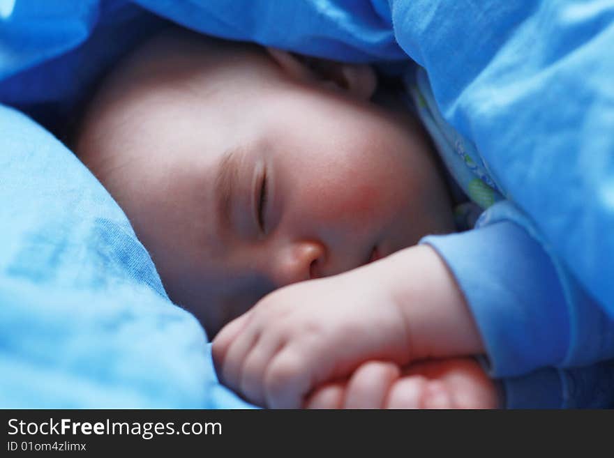 Sleeping baby close up on blue pastel linen. Sleeping baby close up on blue pastel linen