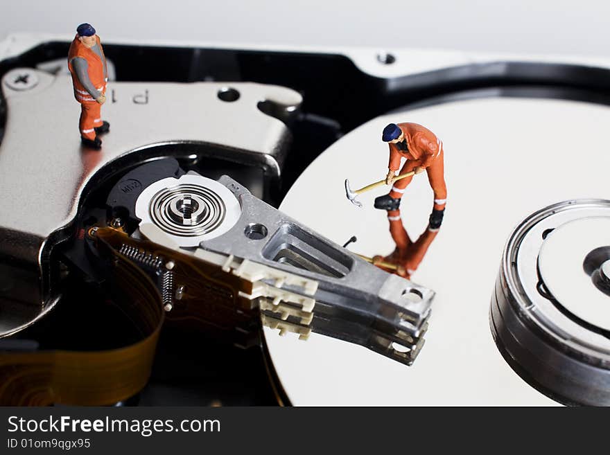 Worker figurine placed on hard drive on white backdrop. Worker figurine placed on hard drive on white backdrop