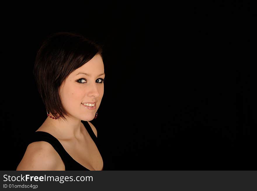 Horizontal closeup portrait of a smiling young woman, isolated against a black background. Horizontal closeup portrait of a smiling young woman, isolated against a black background.