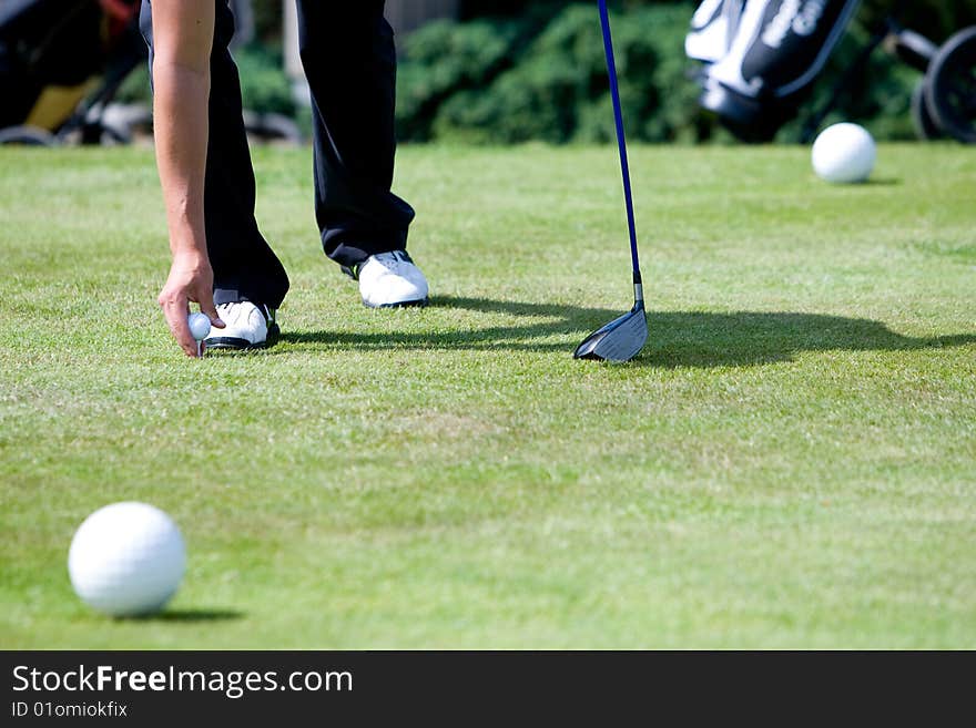 A male golfer is preparing to tee off. A male golfer is preparing to tee off.