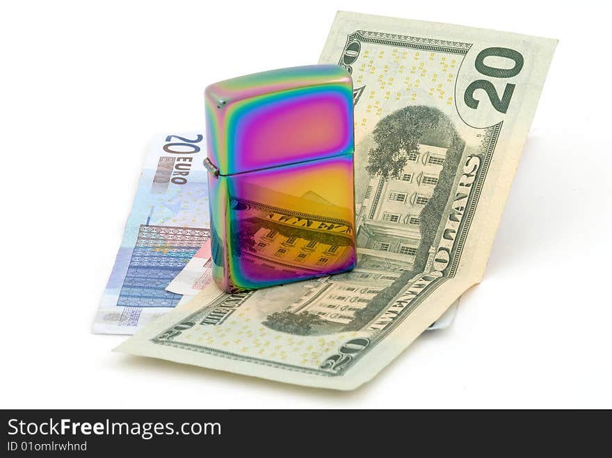 Golden metal cigarette lighter. Euro and dollar banknotes. Selective focus