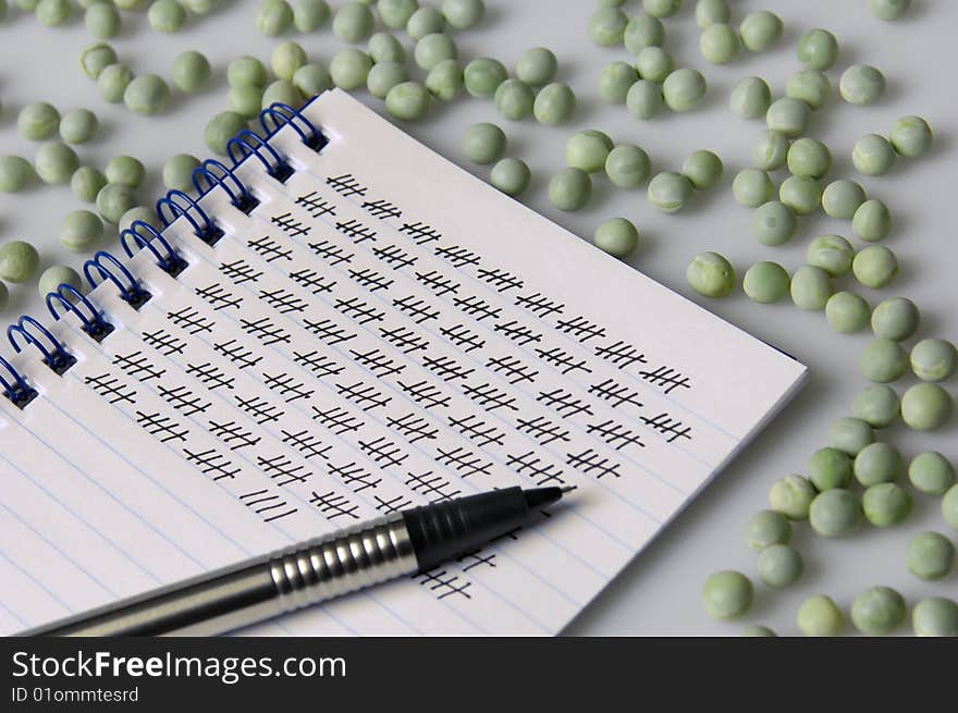 Green peas with Notepad and pencil. Green peas with Notepad and pencil