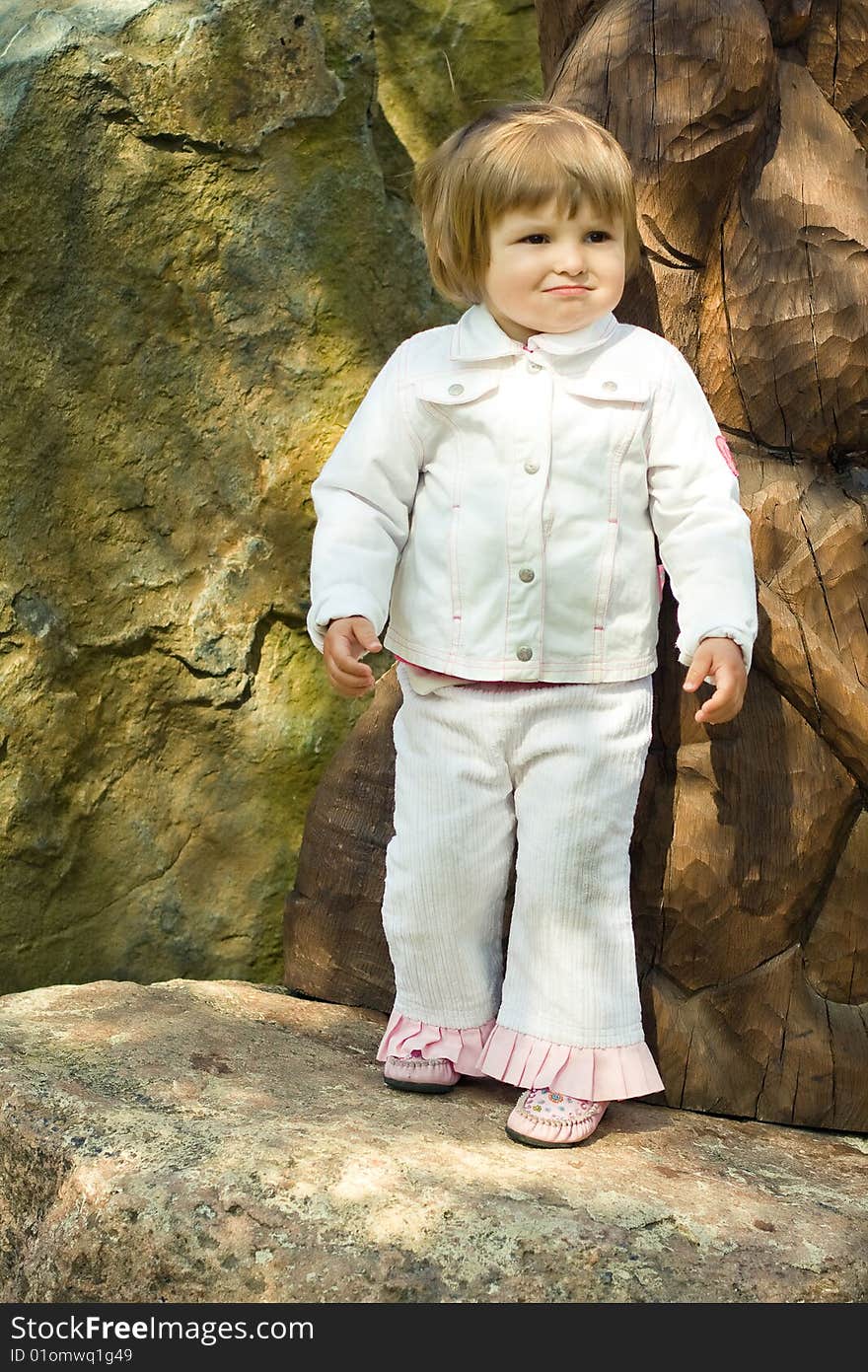 Young girl in park on the stone